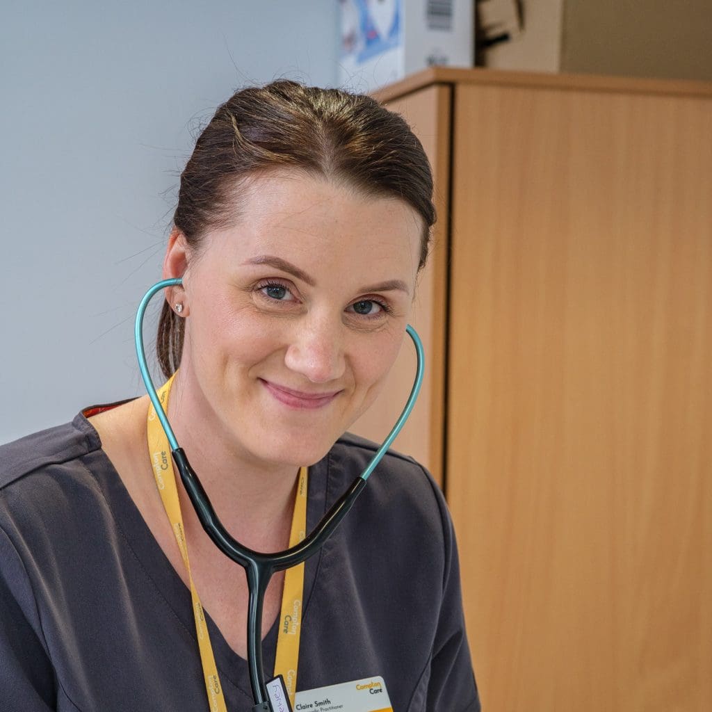 A picture of Claire smiling towards the camera in a grey Compton Care uniform